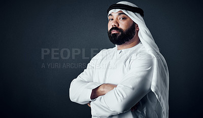 Buy stock photo Studio shot of a young man dressed in Islamic traditional clothing posing against a dark background
