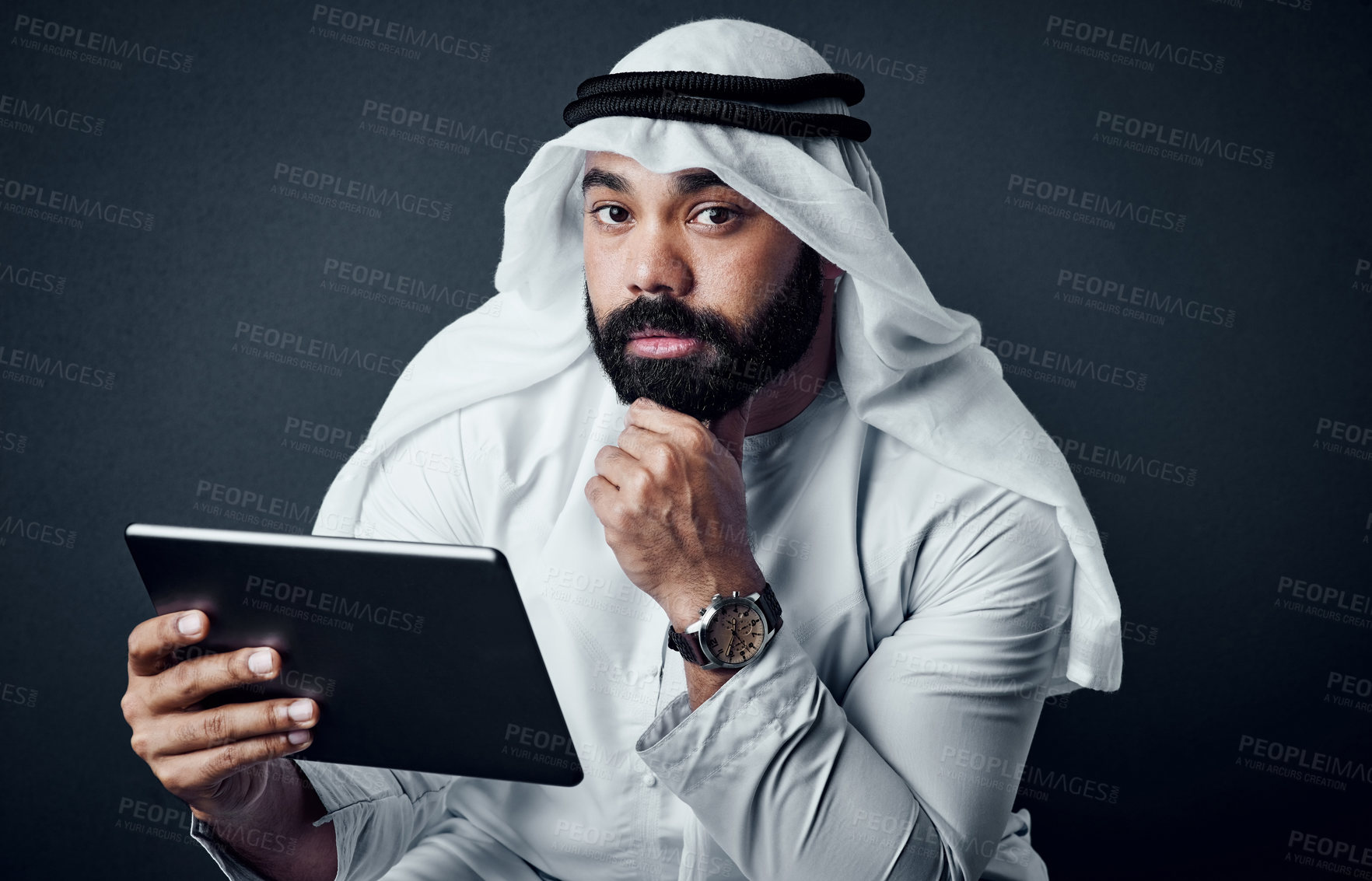 Buy stock photo Studio shot of a young man dressed in Islamic traditional clothing posing against a dark background