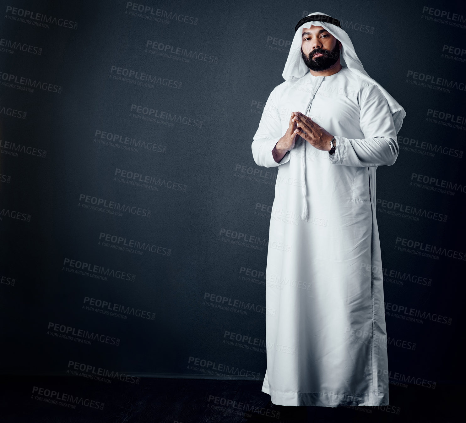 Buy stock photo Studio shot of a young man dressed in Islamic traditional clothing posing against a dark background