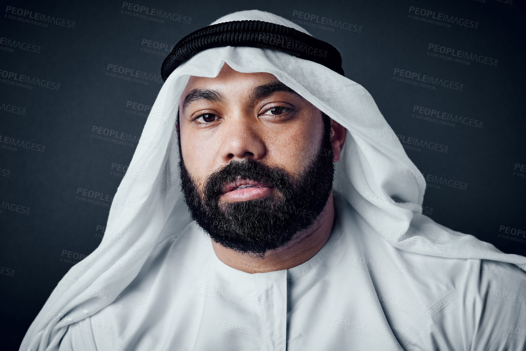 Buy stock photo Studio shot of a young man dressed in Islamic traditional clothing posing against a dark background