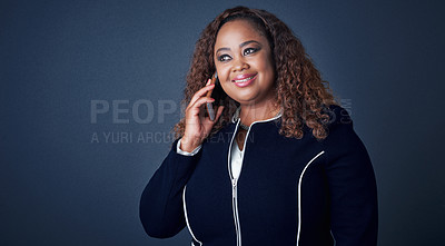 Buy stock photo Studio shot of a cheerful young businesswoman talking on her cellphone to a client while looking in a certain direction