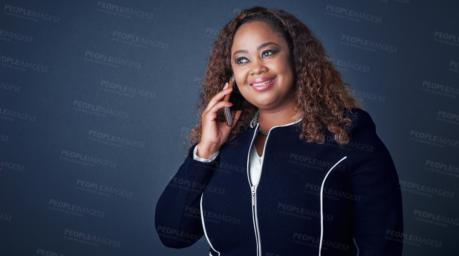 Buy stock photo Studio shot of a cheerful young businesswoman talking on the phone to a client while looking in a certain direction