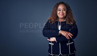 Buy stock photo Portrait of a cheerful young businesswoman standing with her arms folded while standing against a blue background