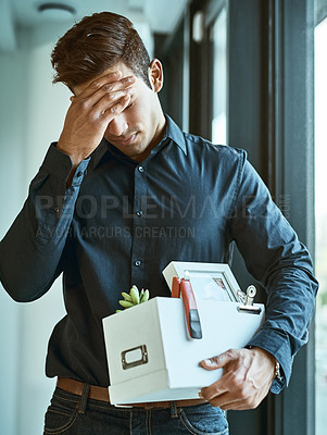 Buy stock photo Shot of an unhappy businessman holding his box of belongings after getting fired from his job