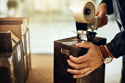 Buy stock photo Closeup shot of a delivery man sealing a box with tape