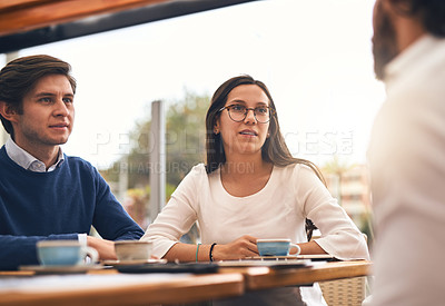 Buy stock photo Shot of a group of creative businesspeople having a meeting around a table outside of a coffeeshop