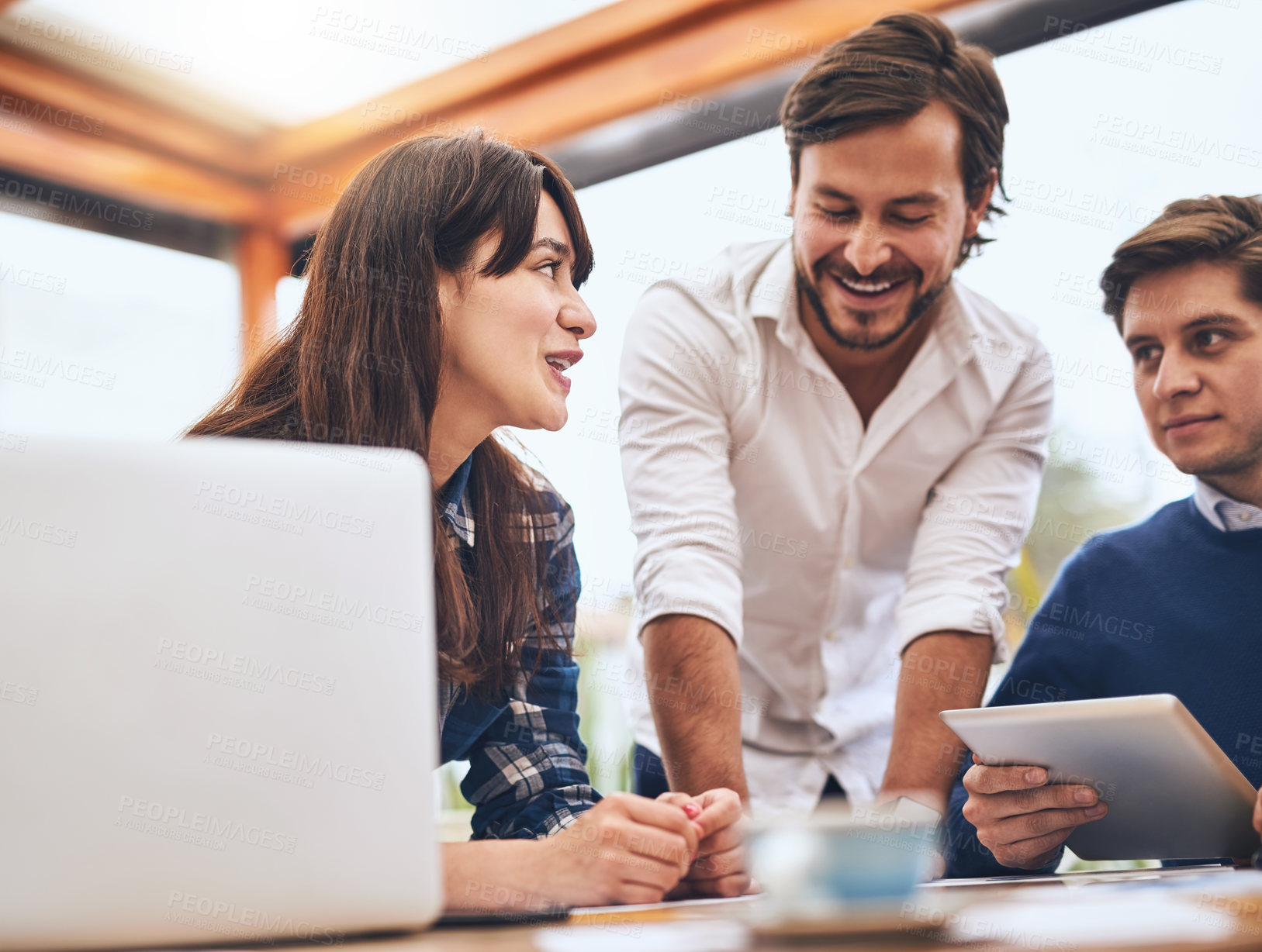 Buy stock photo Shot of a group young creative businesspeople working together around a table outside of a coffeeshop