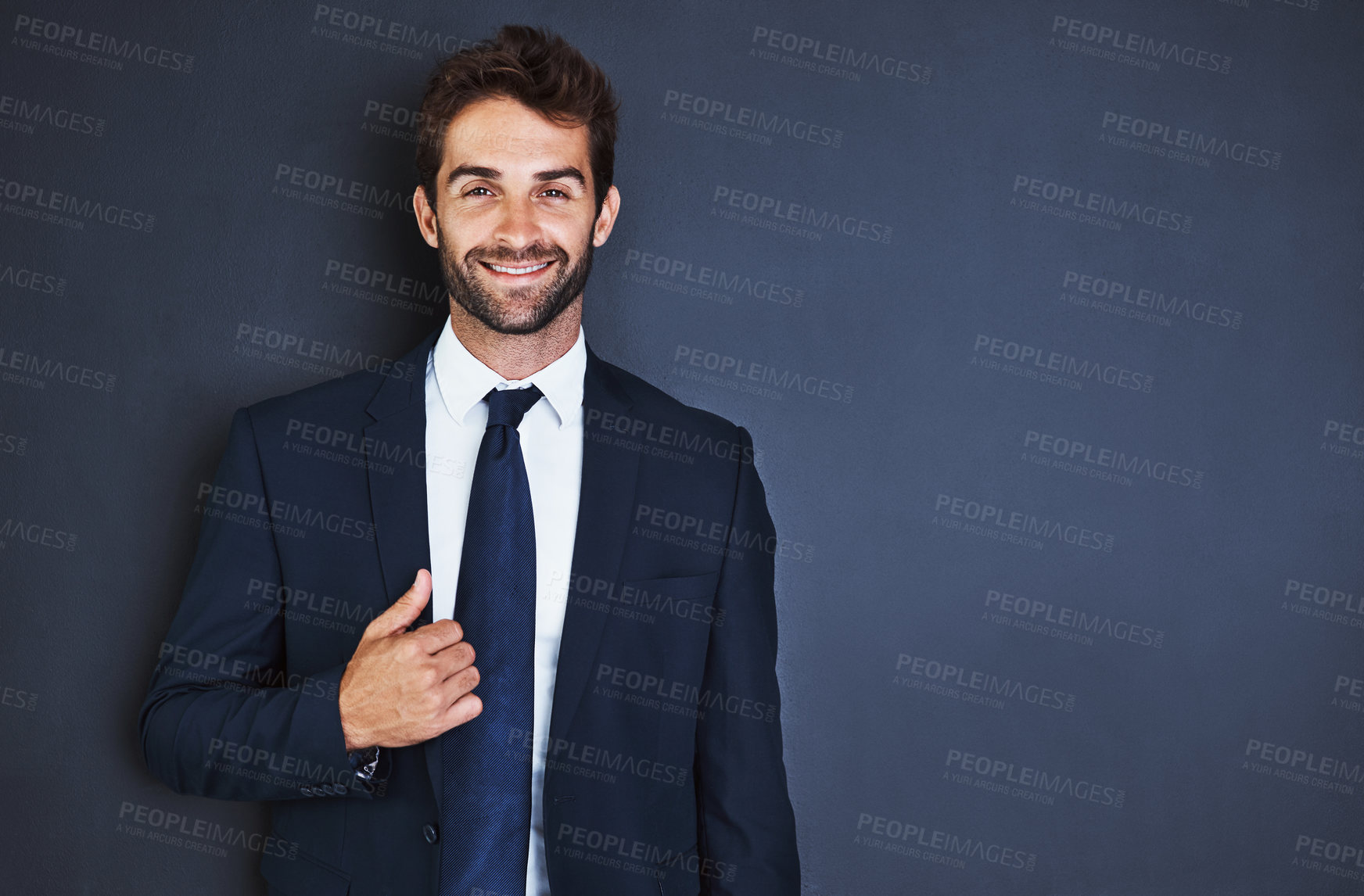 Buy stock photo Studio portrait of a handsome young businessman standing against a grey background