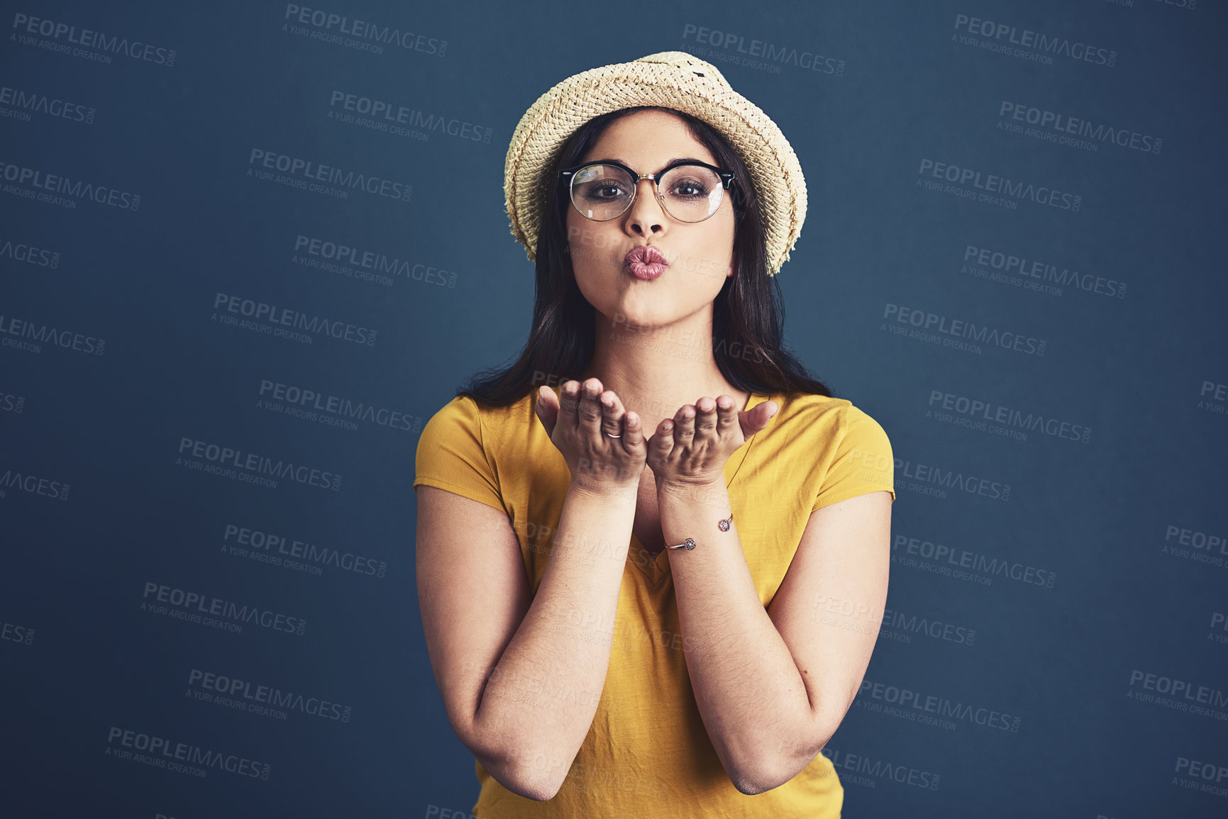 Buy stock photo Woman portrait, blowing kiss and love in studio, romance and flirting gesture on blue background. Female person, confident and emoji for seduction on mockup space, passion and care on valentines day