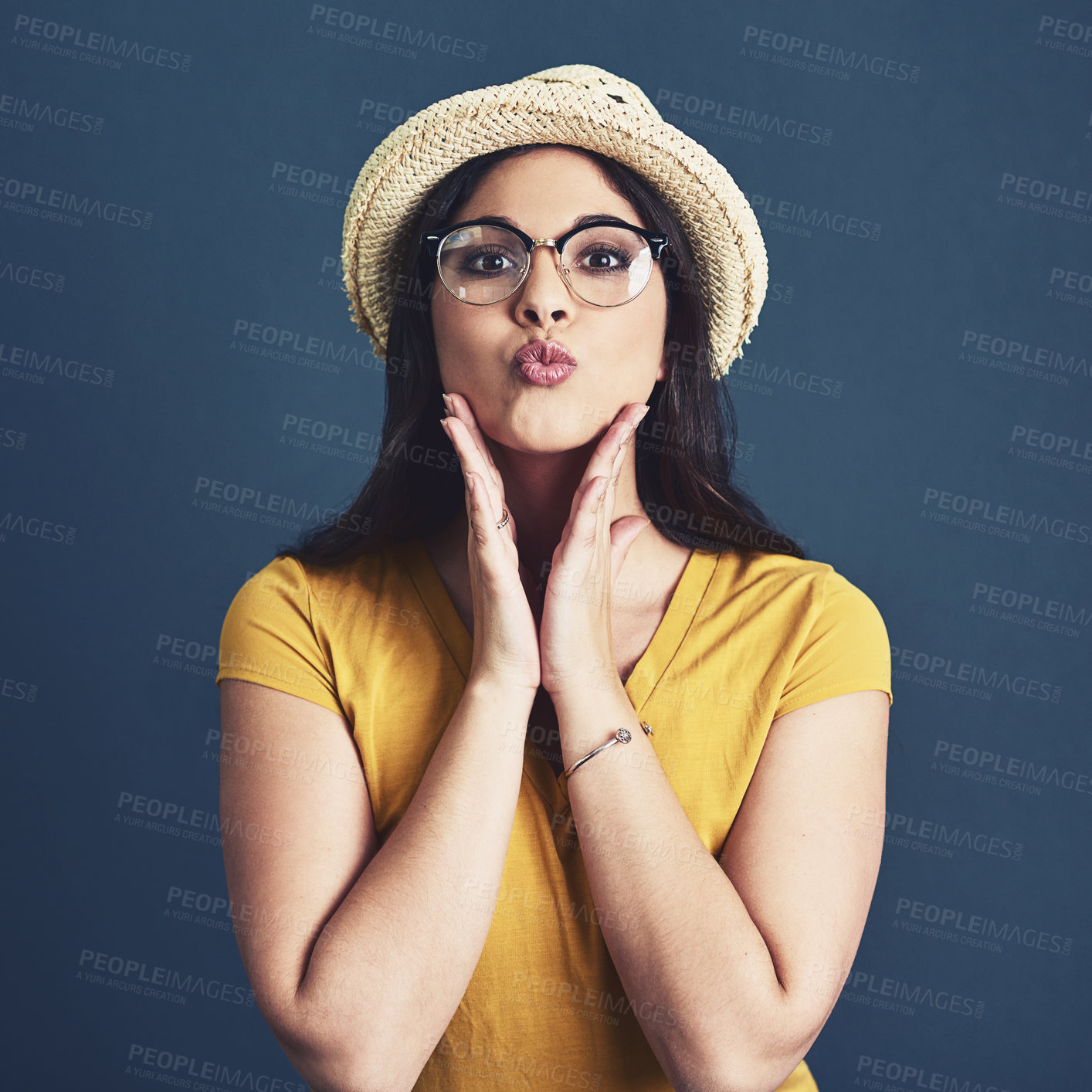 Buy stock photo Portrait, pouting and woman with glasses, fashion and playful girl on blue studio background. Face, person and model with eyewear, fun and hat with happiness, aesthetic and stylish with confidence