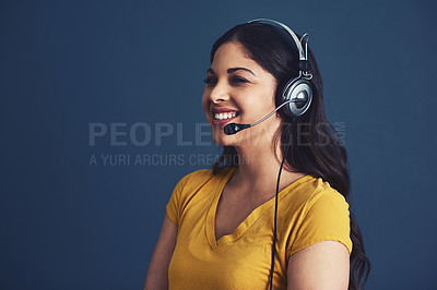 Buy stock photo Studio shot of an attractive young woman wearing a headset against a blue background