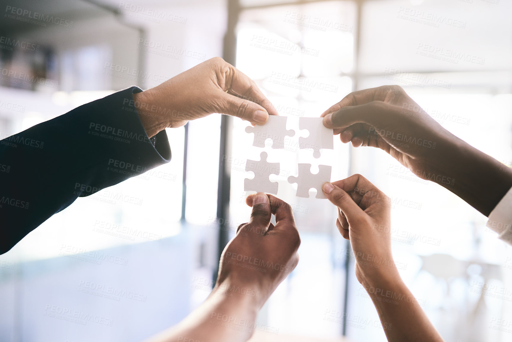 Buy stock photo Shot of a motivated group of unrecognizable businesspeople each holding a puzzle piece next to each other