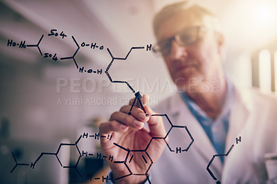 Buy stock photo Shot of a focused mature male scientist solving equations on a glass wall in a laboratory