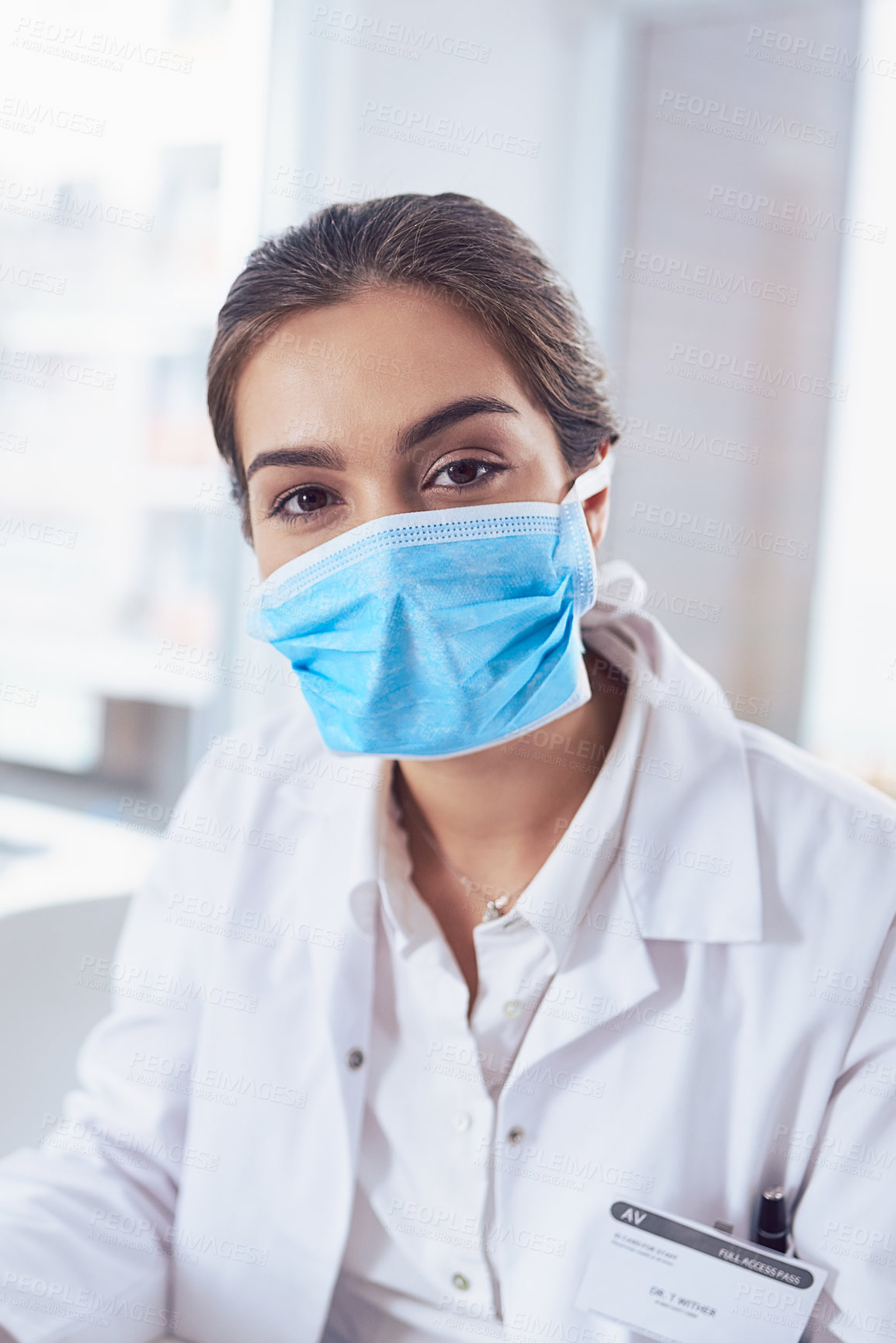 Buy stock photo Portrait of a confident young female scientist wearing a surgical mask while looking at the camera