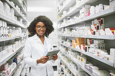 Buy stock photo Portrait of a cheerful young female pharmacist standing with a digital tablet while looking at the camera in a pharmacy