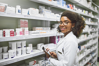 Buy stock photo Portrait of a cheerful young female pharmacist holding a digital tablet while looking at the camera in a pharmacy