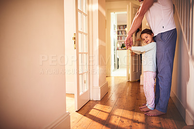 Buy stock photo Portrait of a cheerful little girl playing around the house with her dad while she looks at the camera at home