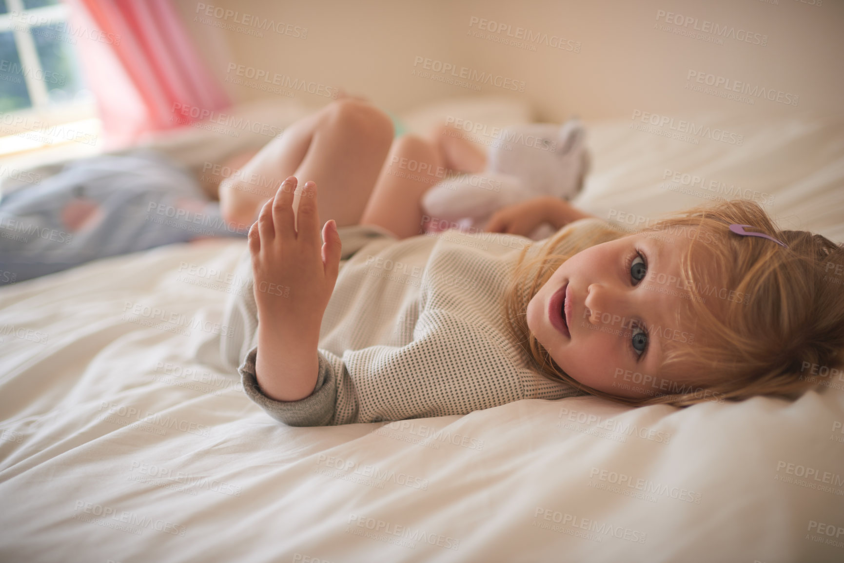 Buy stock photo Portrait of an adorable little girl relaxing on the bed at home
