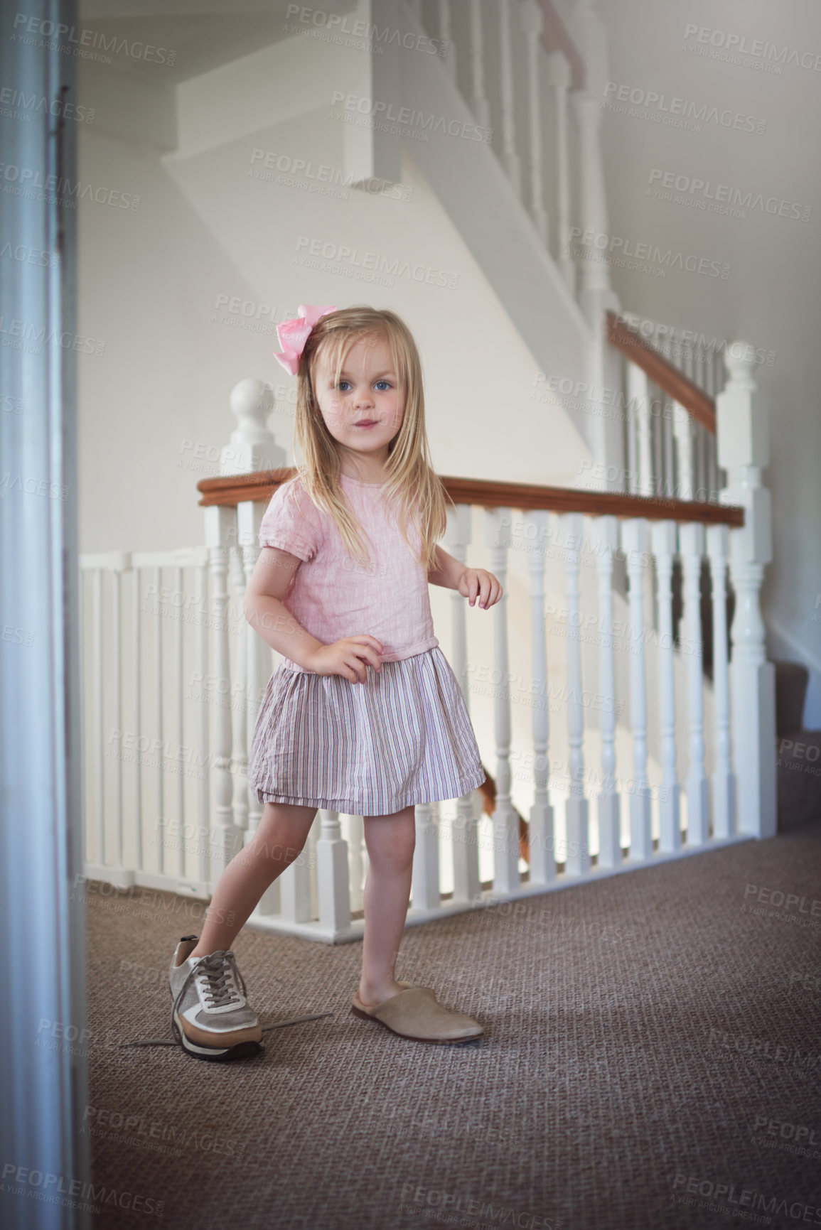 Buy stock photo Shot of an adorable little girl walking around the house in grown up shoes