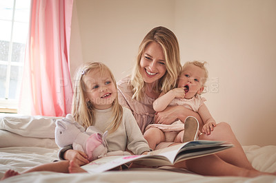 Buy stock photo Mother, children and happy with book on bed in home for language development, storytelling and reading. Family, woman and girl kids in bedroom with fantasy novel for knowledge, bonding and literature