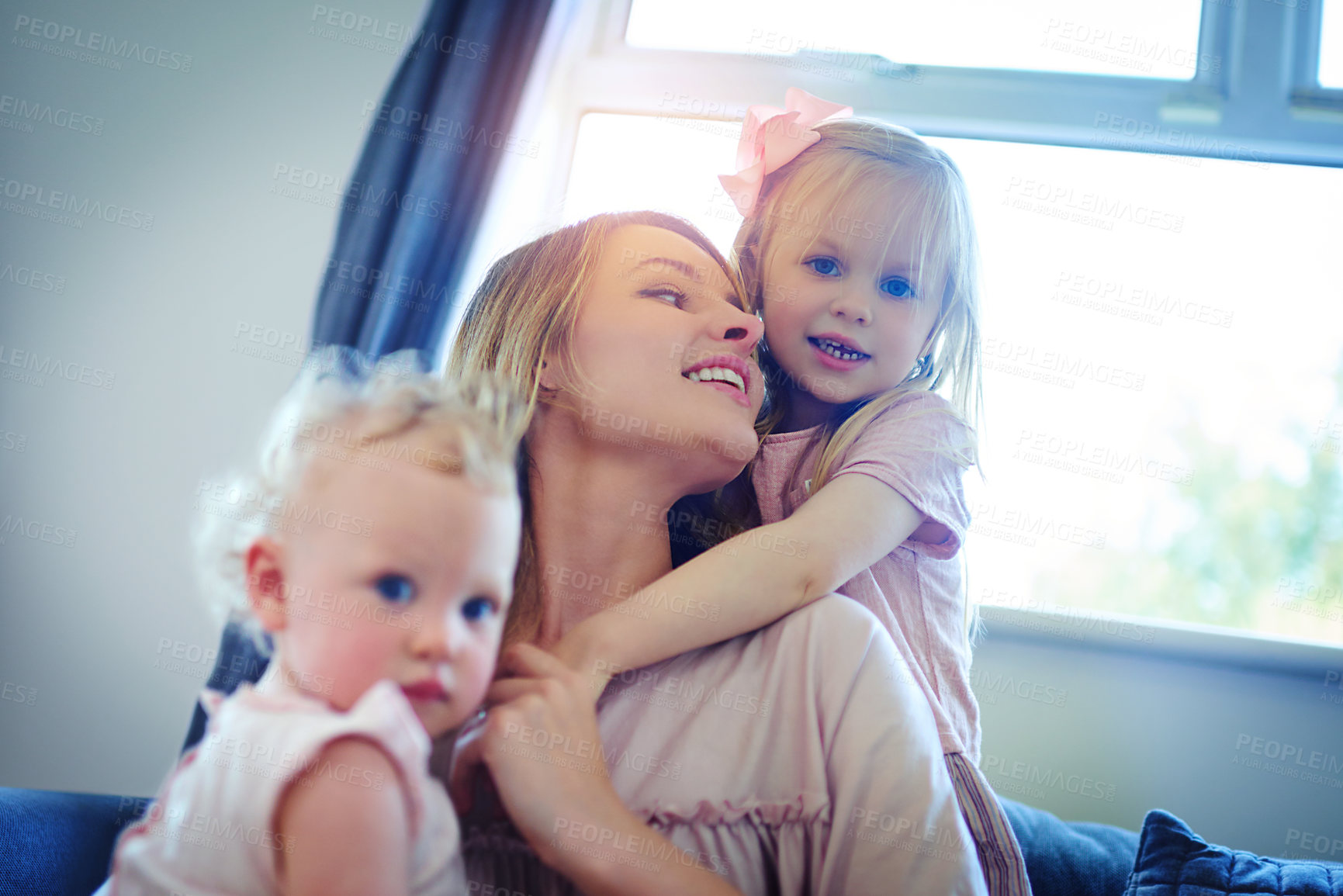 Buy stock photo Shot of two adorable sisters bonding with their mother at home