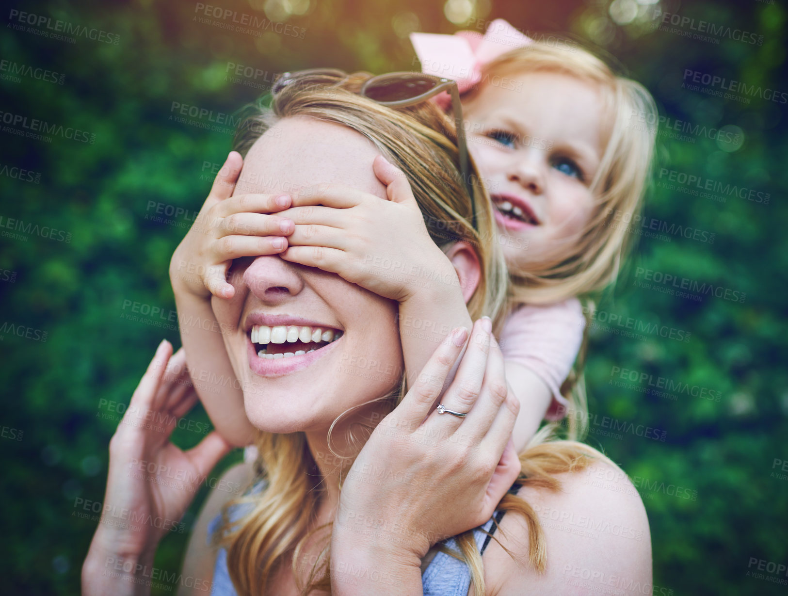 Buy stock photo Shot of an adorable little girl playfully covering her mother’s eyes outdoors