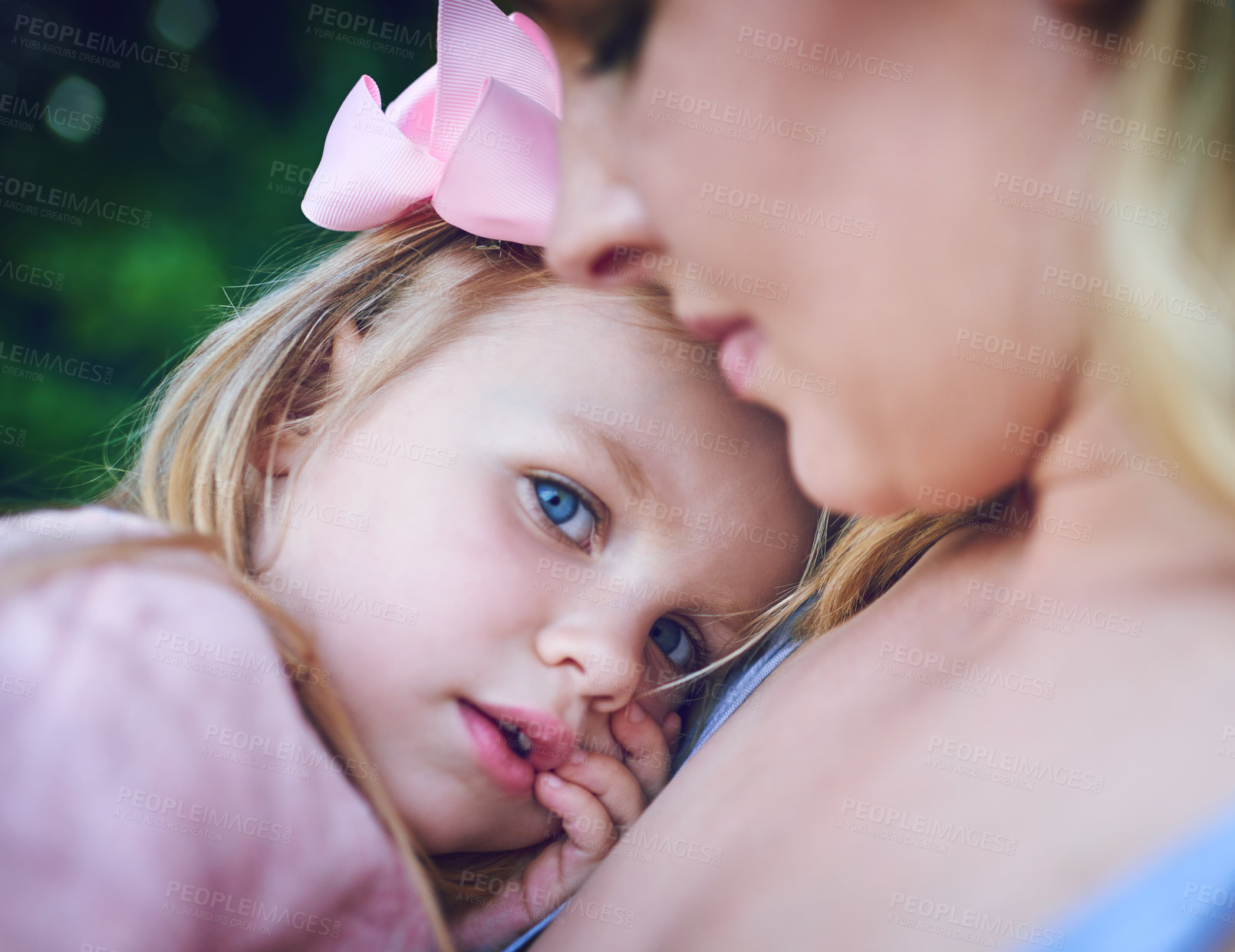 Buy stock photo Shot of an adorable little girl being held by her mother on a day outdoors