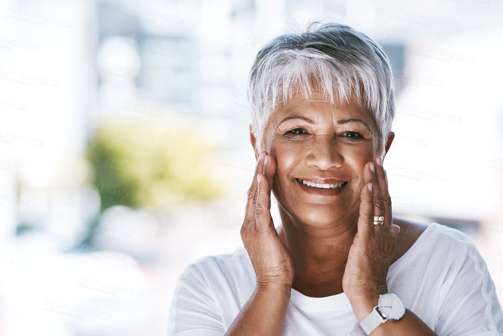 Buy stock photo Portrait of a cheerful mature woman holding her face with her hands while looking at the camera