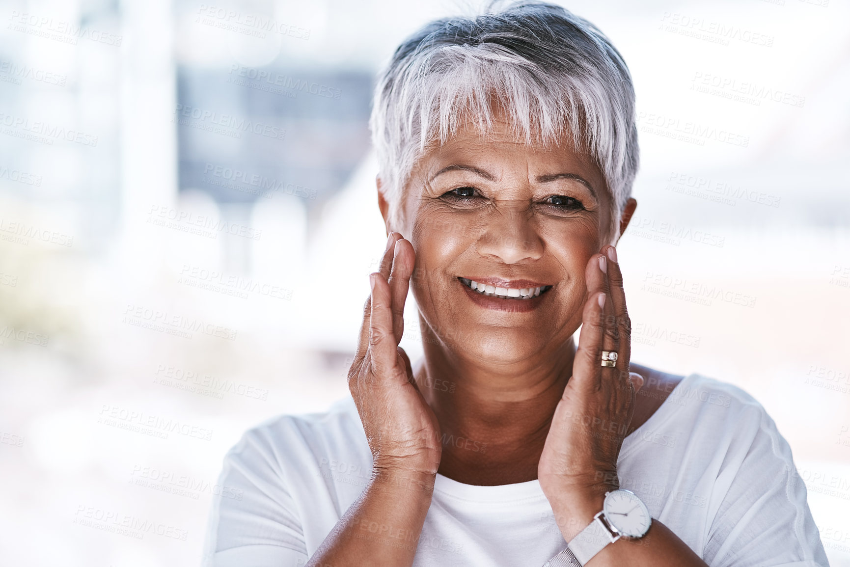 Buy stock photo Portrait of a cheerful mature woman holding her face with her hands while looking at the camera