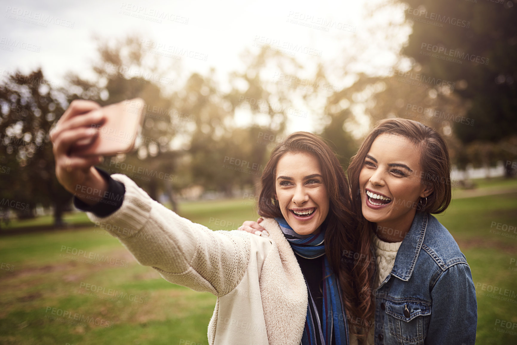 Buy stock photo Shot of two cheerful young friends taking a self portrait together outside in a park