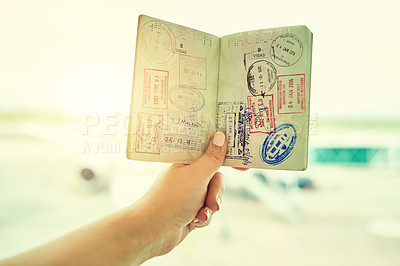 Buy stock photo Shot of an unrecognizable person holding a passport indoors
