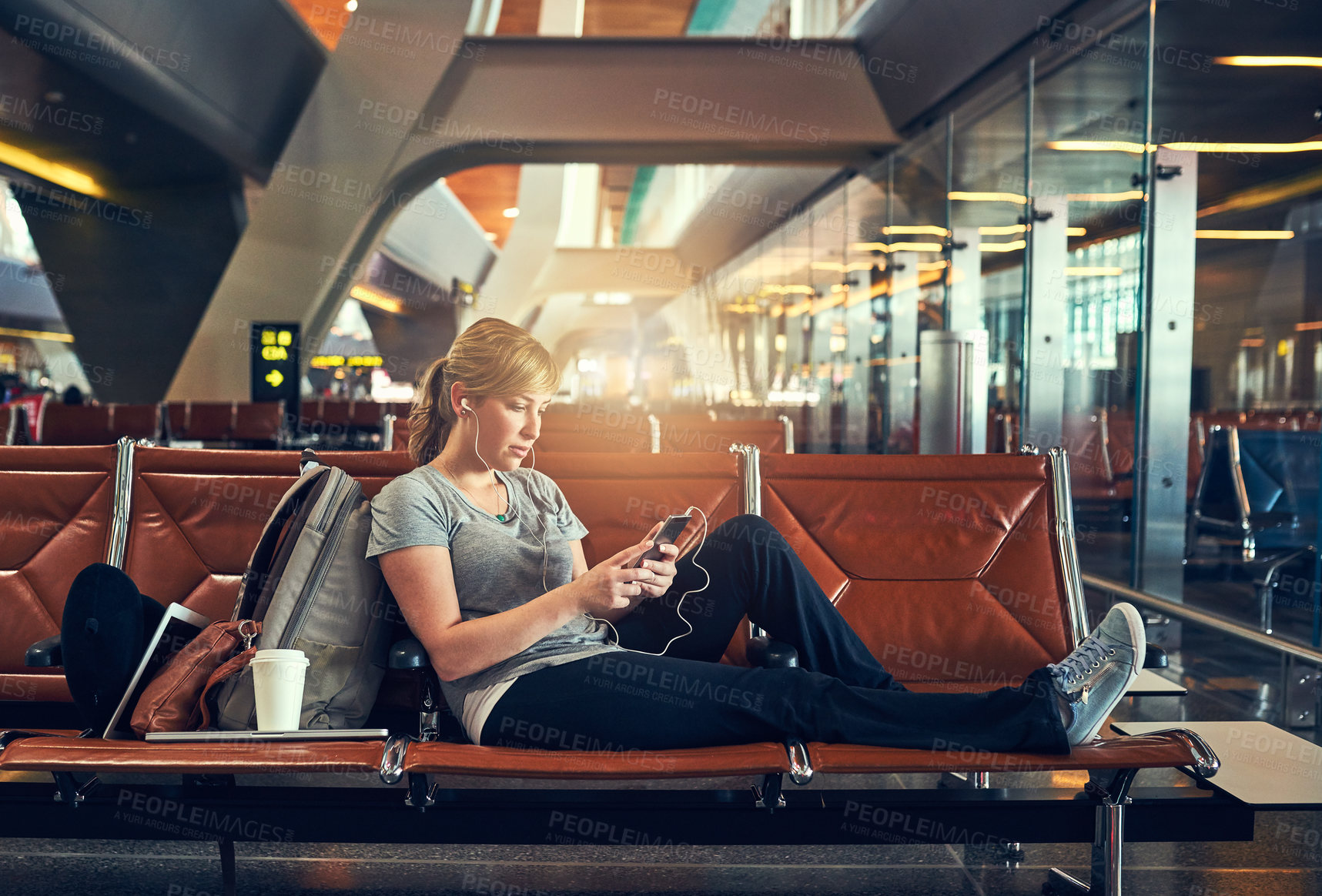 Buy stock photo Shot of a young woman using a cellphone in an airport