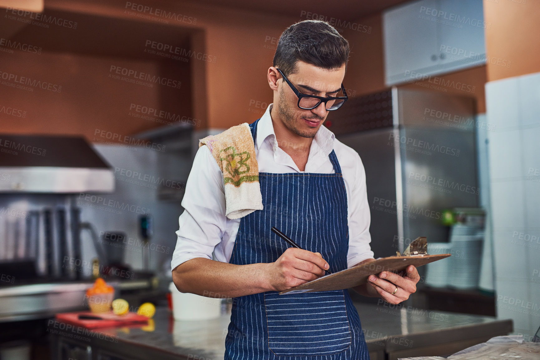 Buy stock photo Kitchen, checklist and man with clipboard for cooking, meal recipe and expert for culinary with ambition. Restaurant, male chef and cook by counter for hospitality, customer service or small business