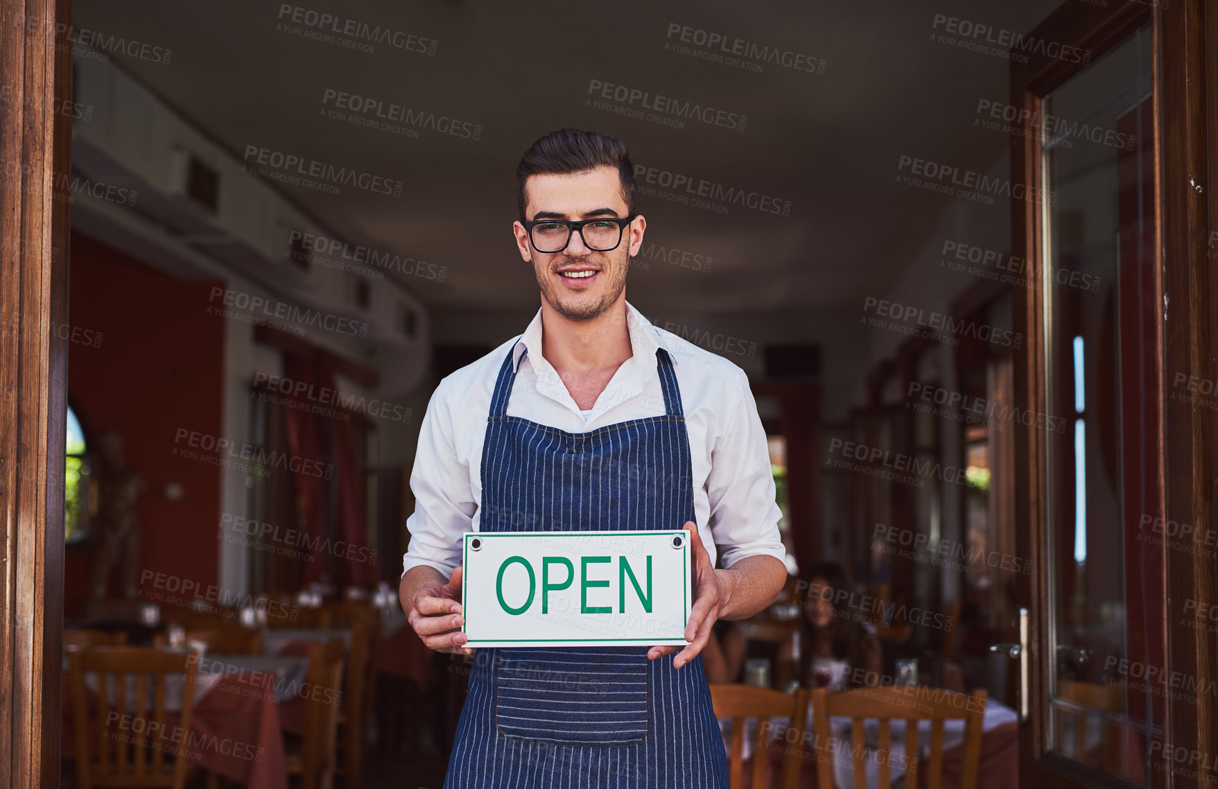 Buy stock photo Shot of a man putting the open sign up at a restaurant