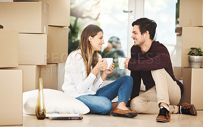 Buy stock photo Shot of an affectionate young couple taking a coffee break while moving into a new home
