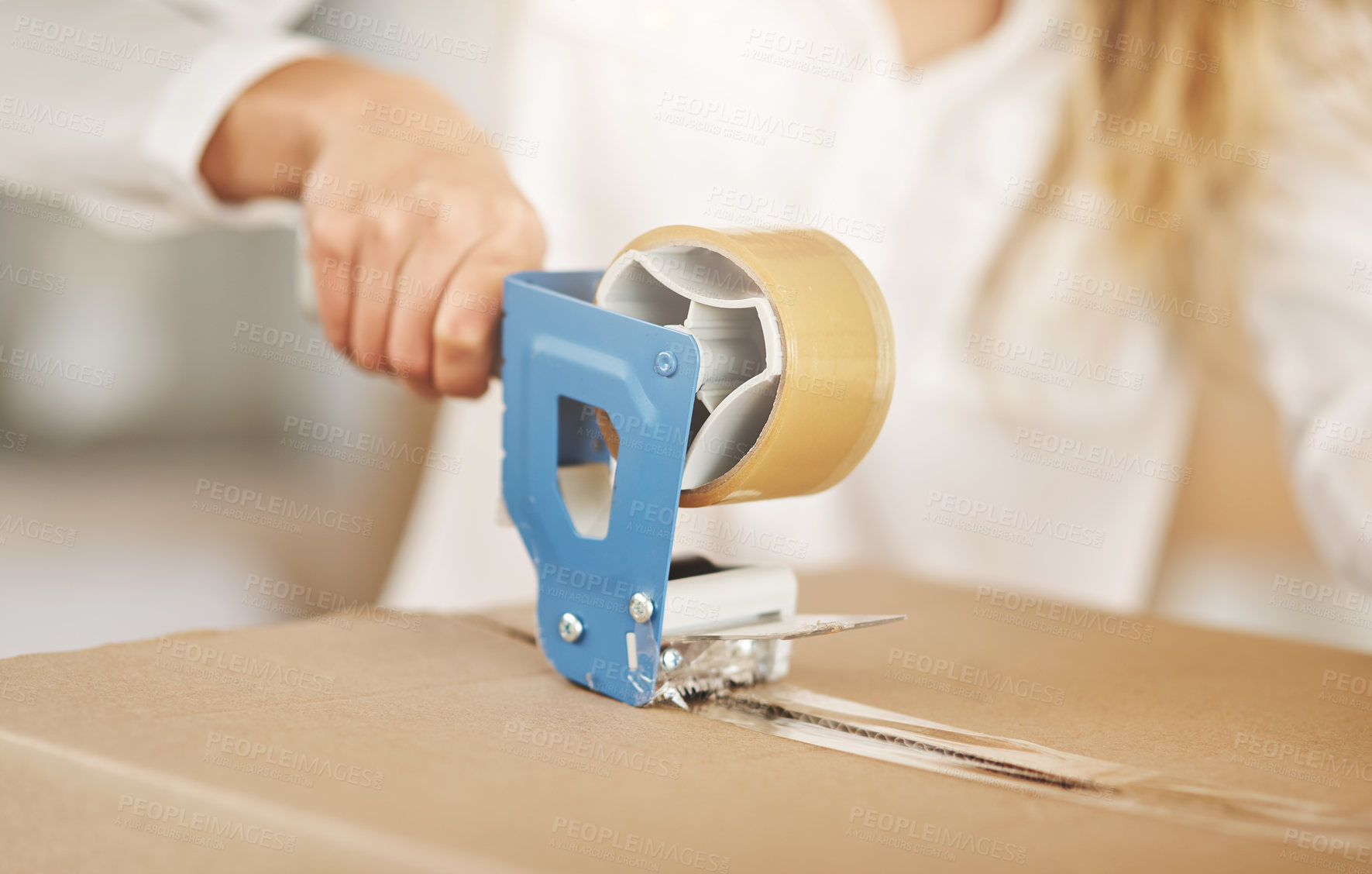 Buy stock photo Closeup shot of an unrecognizable woman sealing a box on moving day