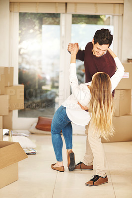 Buy stock photo Full length shot of an affectionate young couple dancing while moving into a new home
