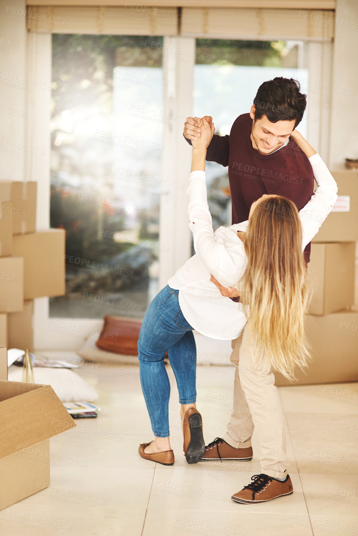 Buy stock photo Full length shot of an affectionate young couple dancing while moving into a new home