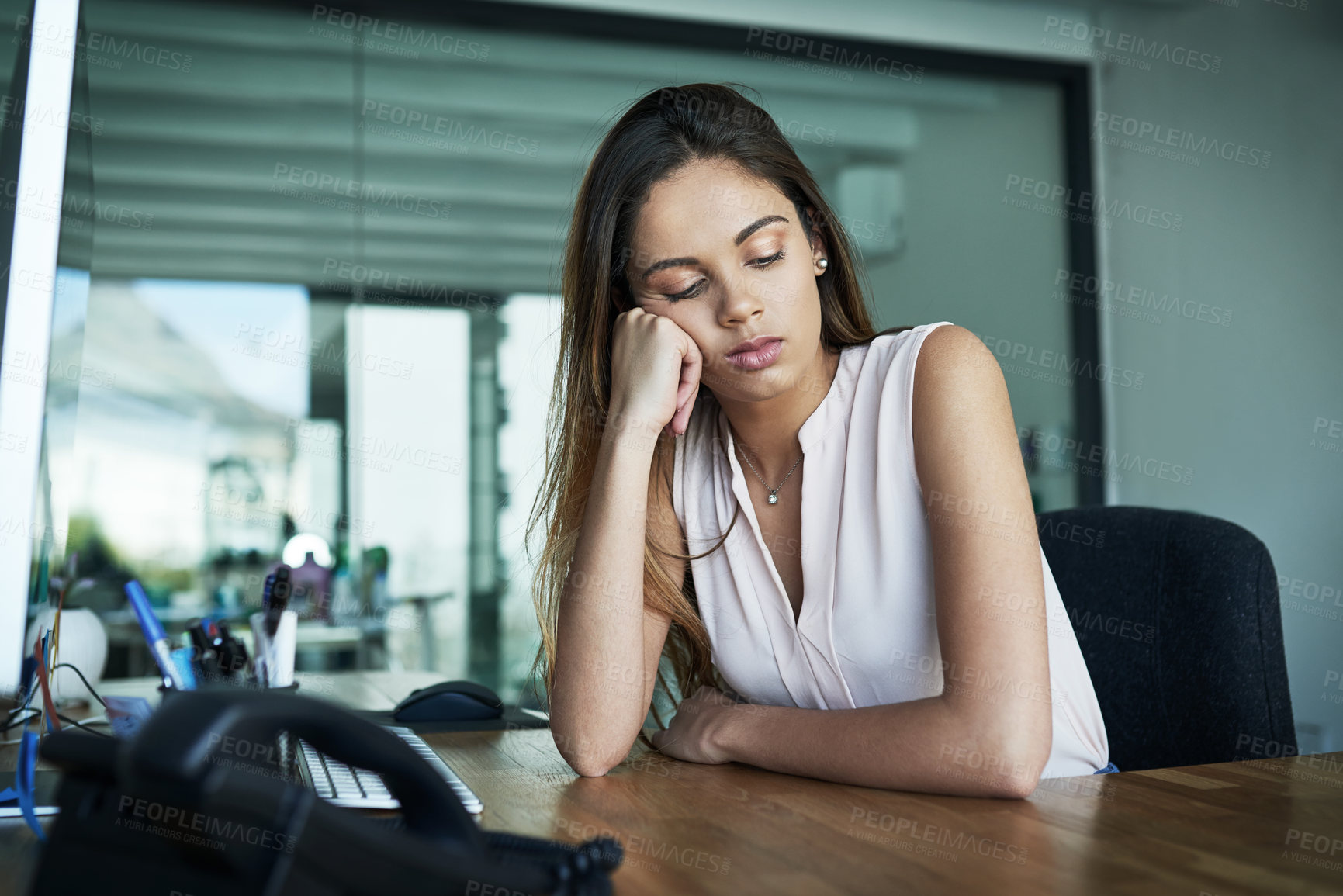 Buy stock photo Shot of a young businesswoman looking bored while working in an office