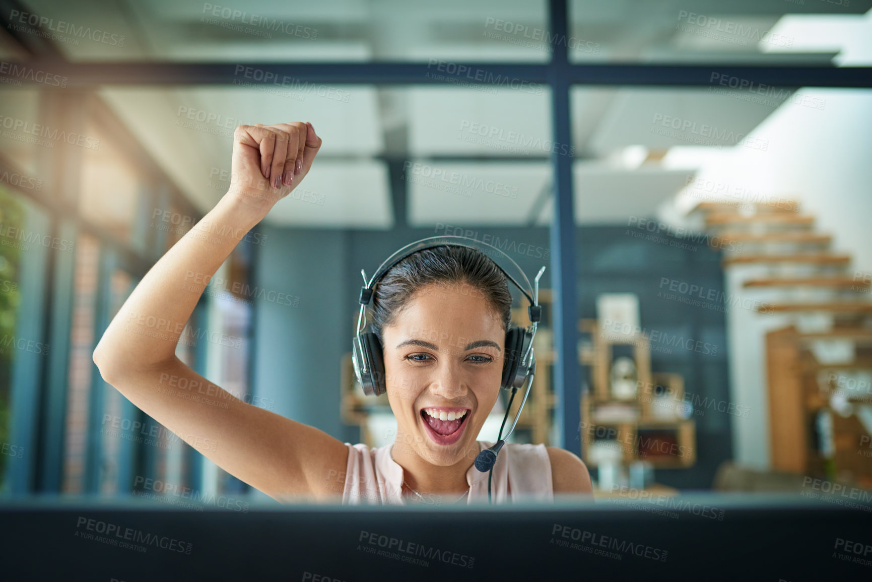 Buy stock photo Shot of a young woman working in a call center and cheering