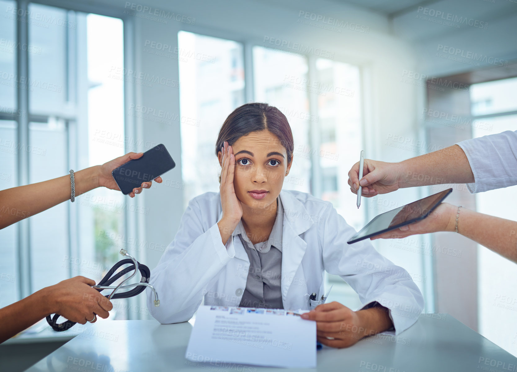 Buy stock photo Portrait of a young female doctor looking stressed out in a demanding work environment