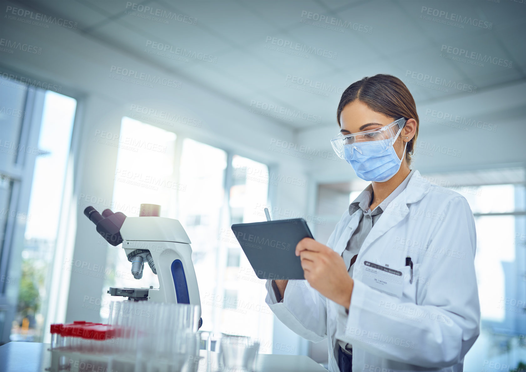 Buy stock photo Shot of a female scientist using a digital tablet in a lab