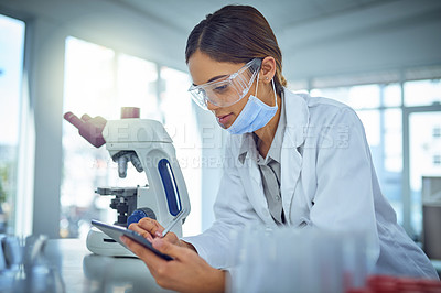 Buy stock photo Shot of a female scientist using a digital tablet in a lab