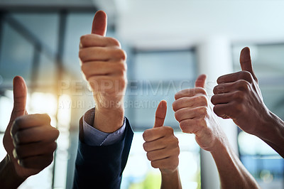 Buy stock photo Thumbs up, support and hand sign shown by professional corporate business people in an office together. Employees and colleagues working and showing unity, satisfaction and agreement with thumb sign