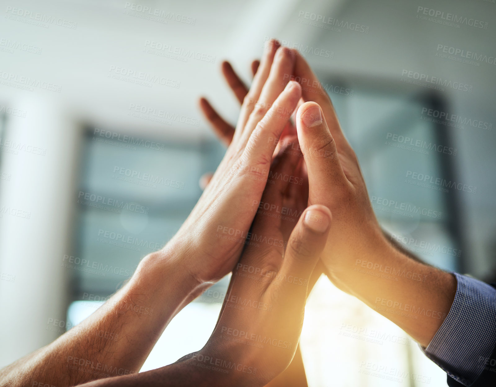 Buy stock photo High five of a diverse group of businesspeople celebrate, unite and support each other. Closeup of a multiethnic corporate professional team hands touching showing success inside a startup office