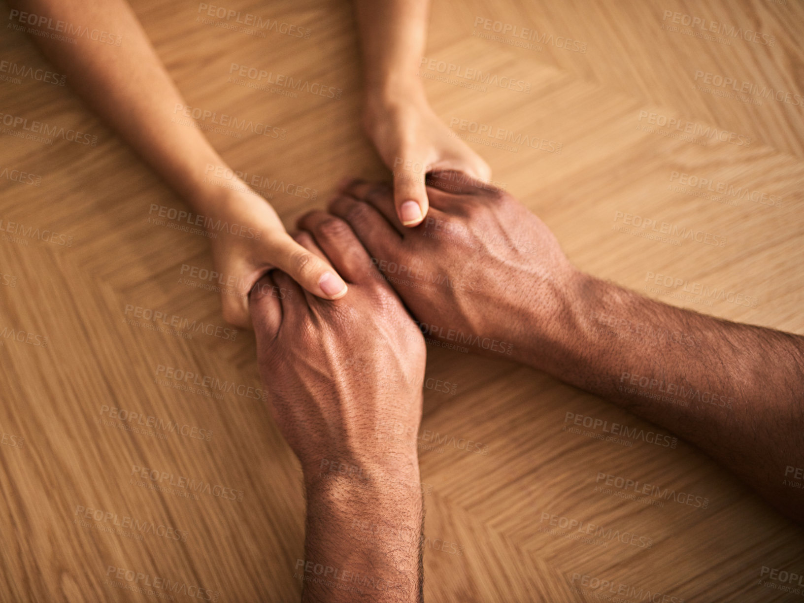 Buy stock photo Couple holding hands showing love, romance and support while sitting at a table from above. Top view of a loving husband and wife sharing affectionate touch, caring and helping with a hand gesture