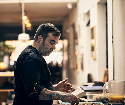 Buy stock photo Shot of a focused chef preparing a dish in the kitchen of a restaurant