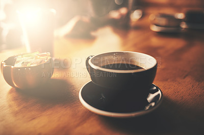 Buy stock photo Shot of a cup of freshly brewed coffee on a wooden table of a restaurant