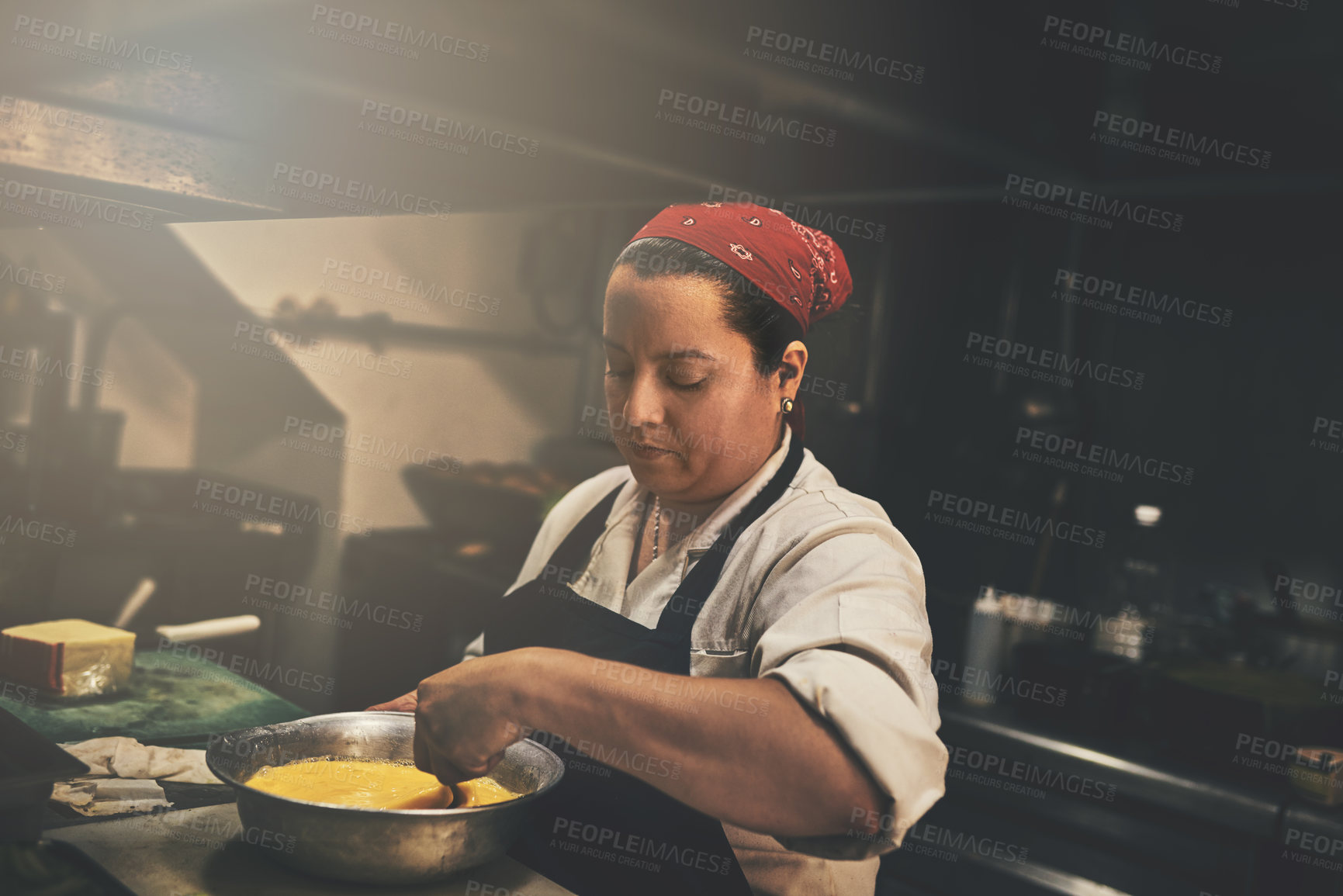 Buy stock photo Shot of a focused chef preparing a dish in the kitchen of a restaurant