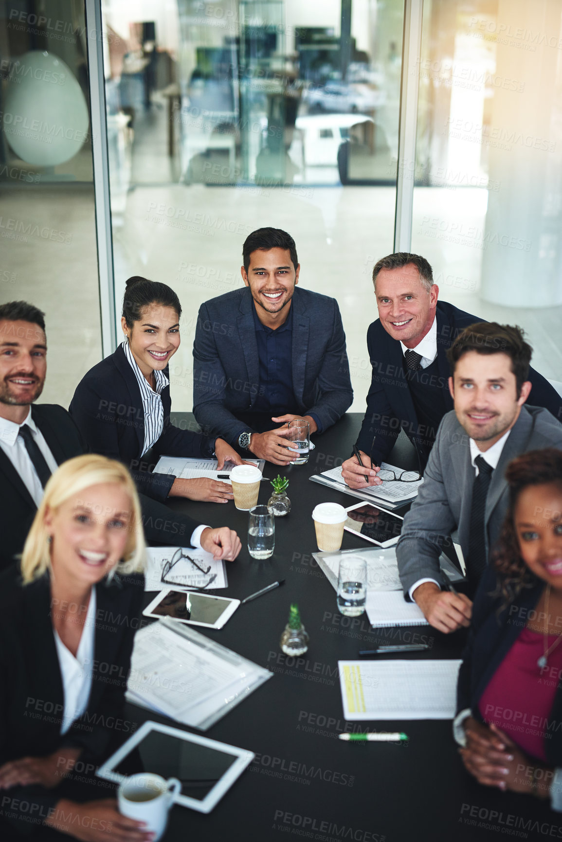 Buy stock photo Portrait of a group of businesspeople having a meeting together while looking into the camera in a boardroom at the office
